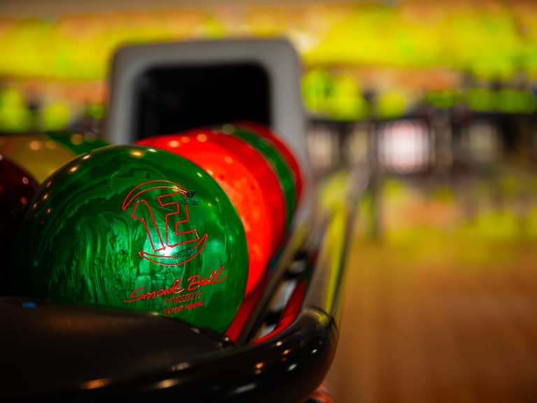 Bilă de bowling pe retur, cu pistele în fundal