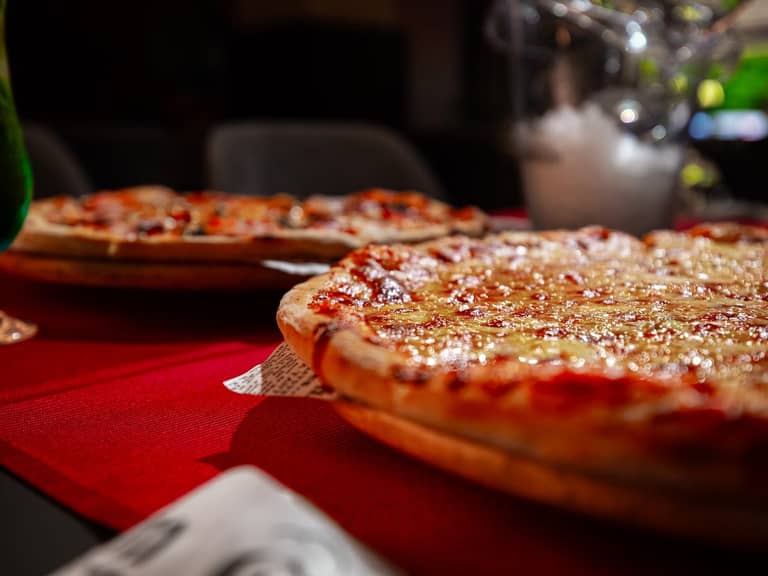 Pizza și băuturi pe masă în restaurant
